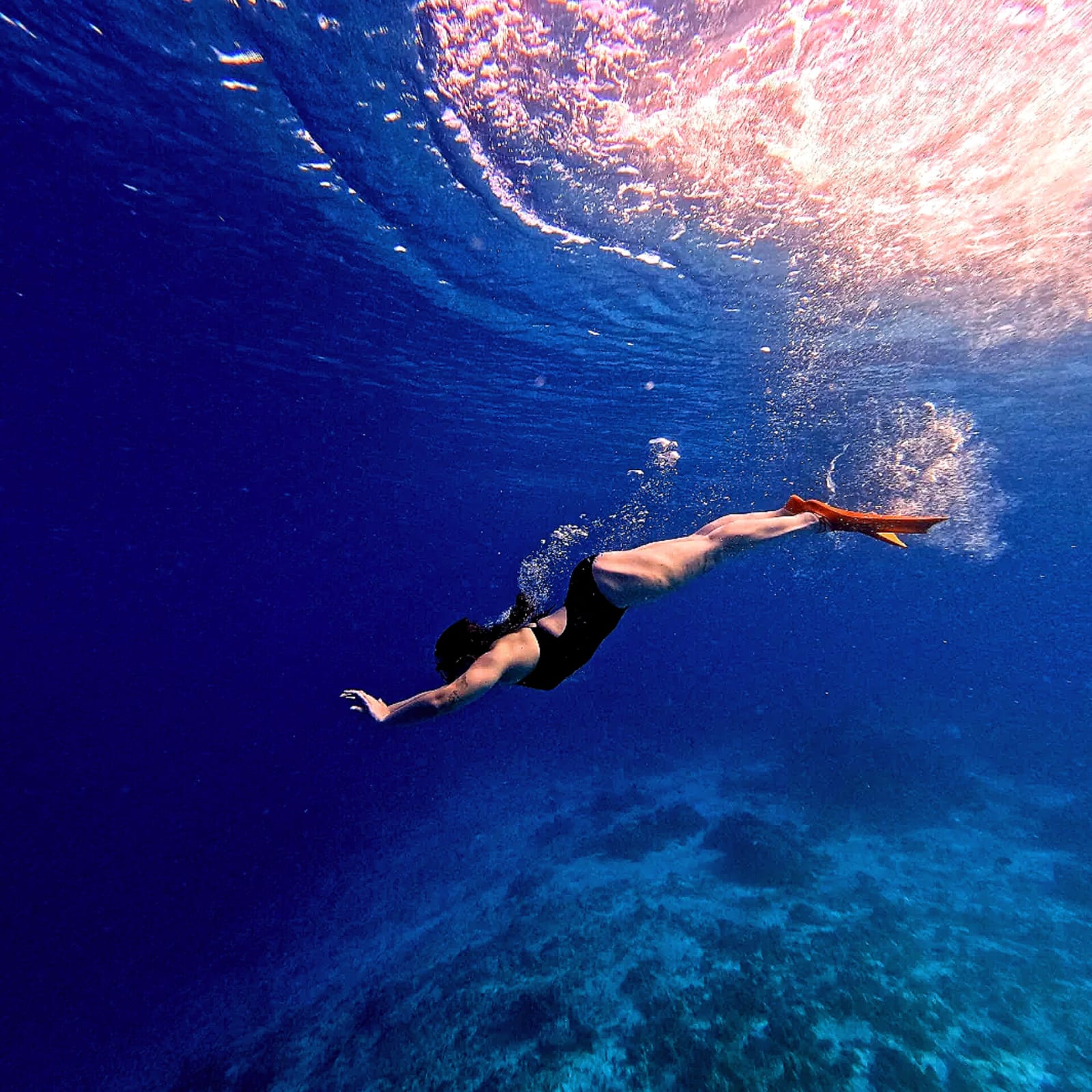 Diver plunging into the deep blue ocean