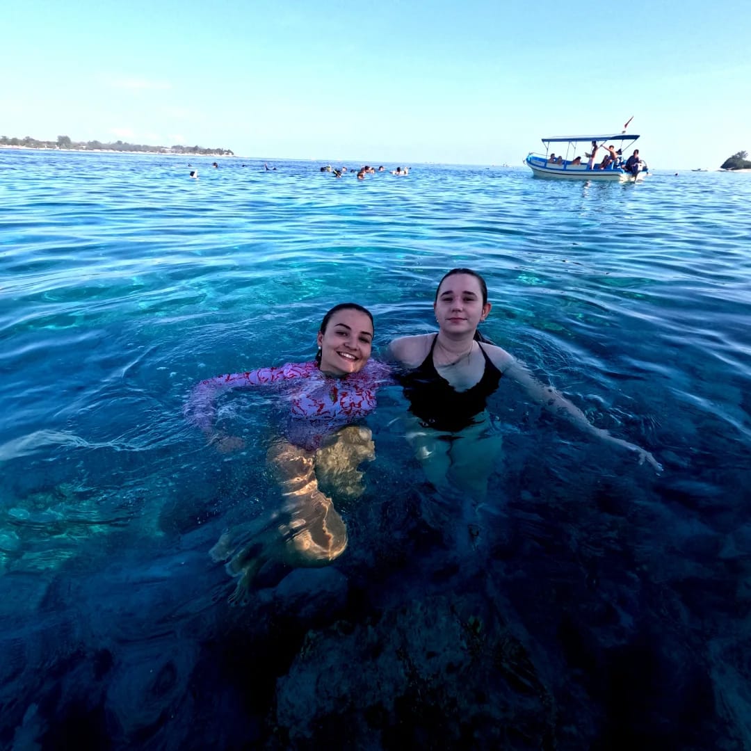 Two guests smiling in the clear Gili waters